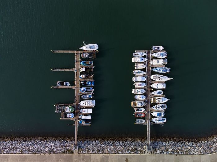 Panoramic aerial view on boats moored in the pier, drone shot directly above. luanco in asturias