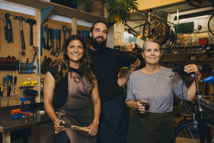 Portrait of smiling colleagues in bicycle workshop