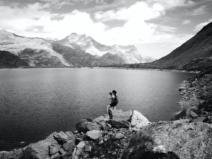 Man looking at lake against mountains