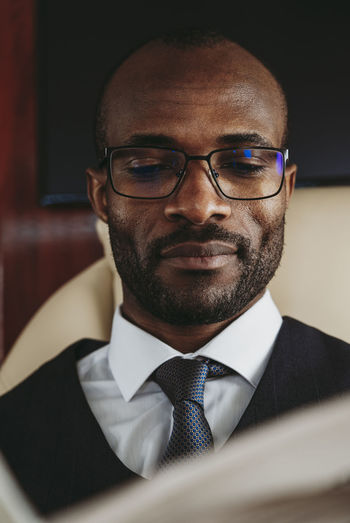 Young businessman with eyeglasses in private jet