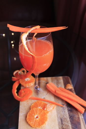 Glass of carrot juice with orange fruits decor