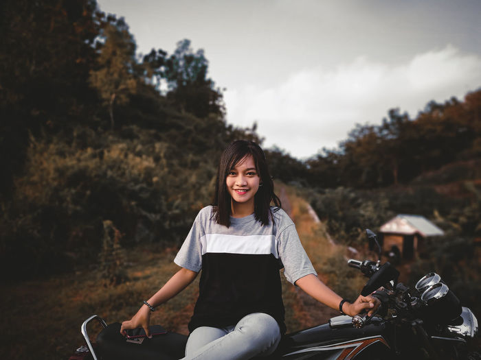 Portrait of smiling woman sitting on her motocycle