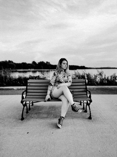 Portrait of woman sitting on bench in park