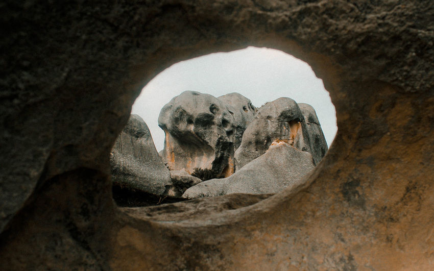 Low angle view of rock formation seen through hole