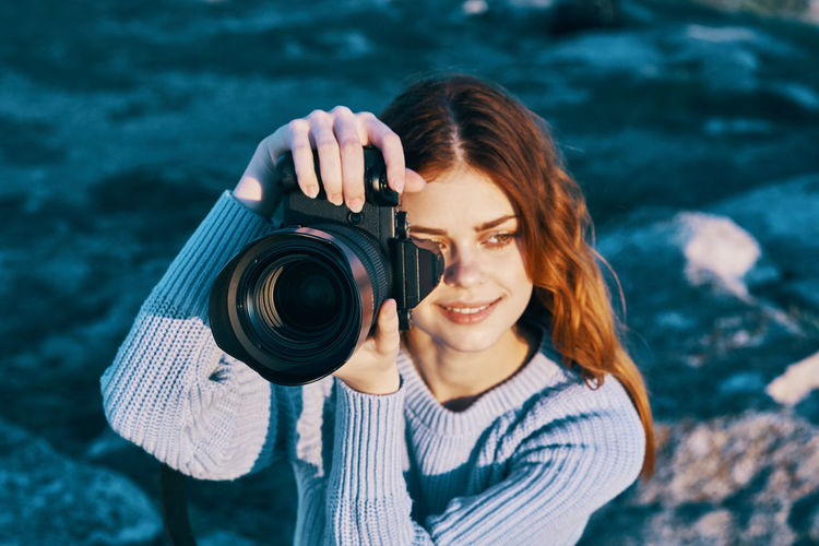 Portrait of young woman photographing camera