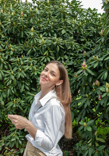 Smiling woman standing by plants