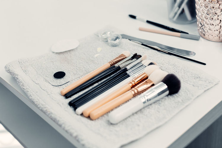 Collection of assorted brushes for makeup arranged on table in bright beauty salon