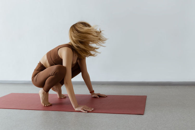 Side view of woman sitting on floor