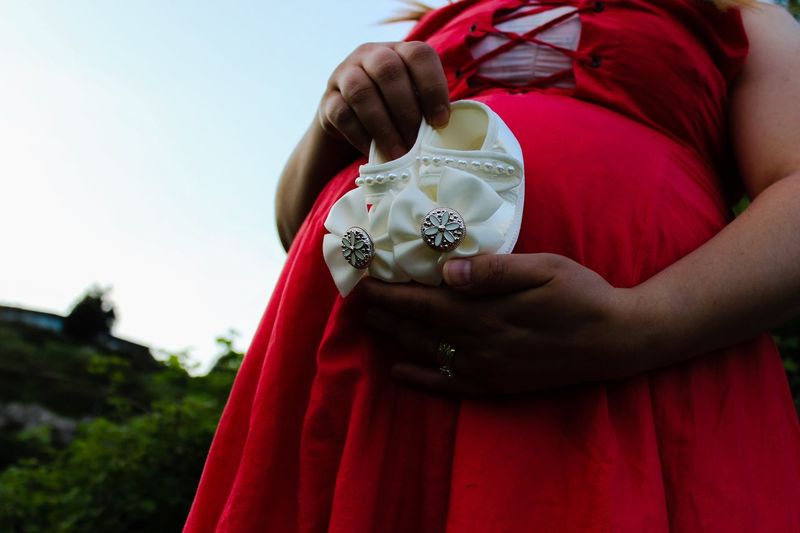 Close-up of pregnant woman holding baby booties