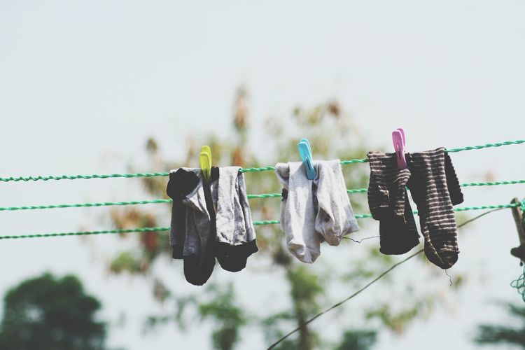 Low angle view of clothes drying on clothesline against sky