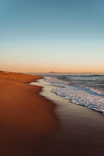 Scenic view of sea against clear sky during sunset