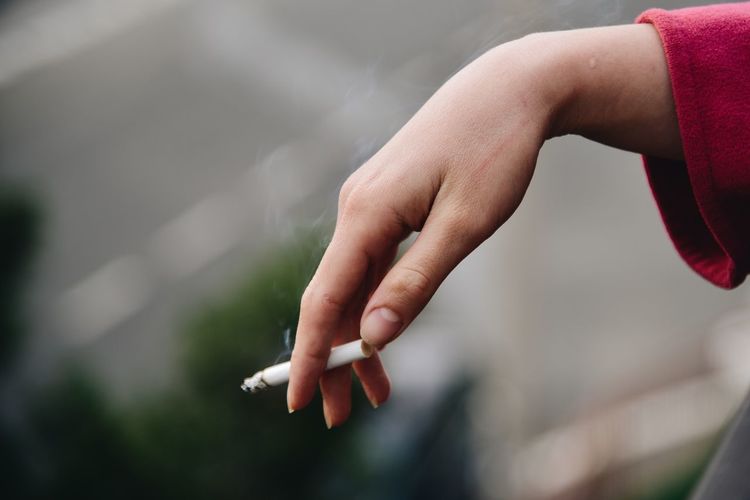 Close-up of hand holding cigarette 