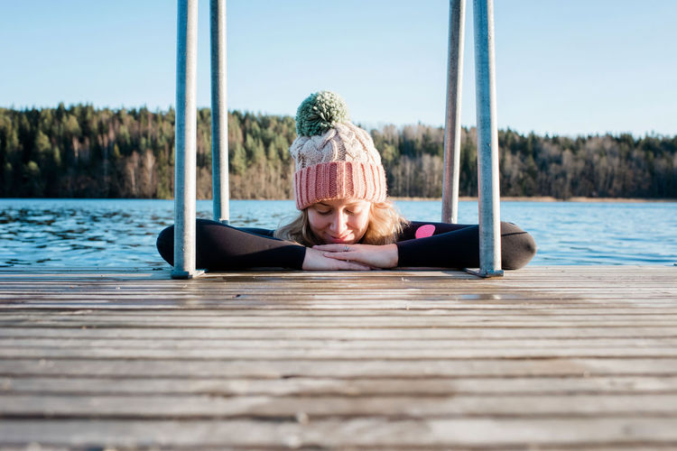 Woman cold water ice swimming in the sea in sweden leaning on a pier