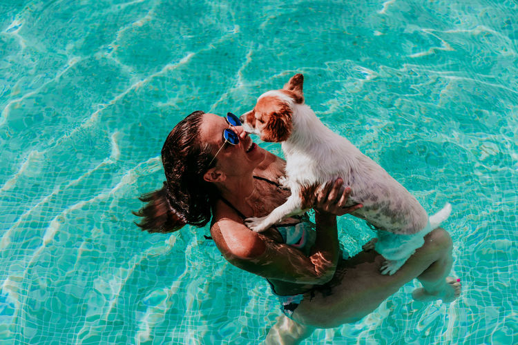 Woman with dog on swimming pool