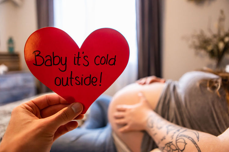 Midsection of woman holding heart shape with text