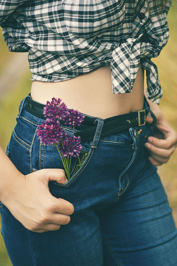 Midsection of woman holding flowering plant