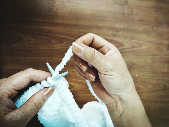Cropped hands of woman knitting fabric