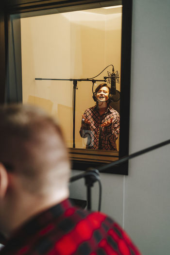 Singer recording music through microphone in studio