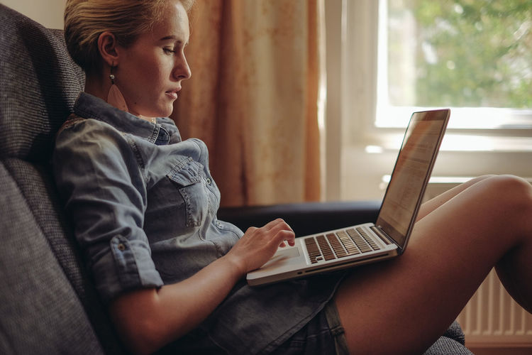 Side view of woman using laptop
