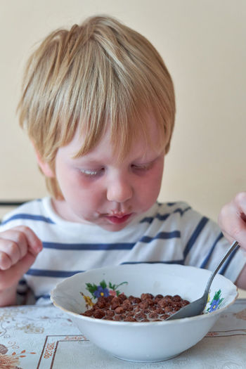 Close-up of boy eating food at home