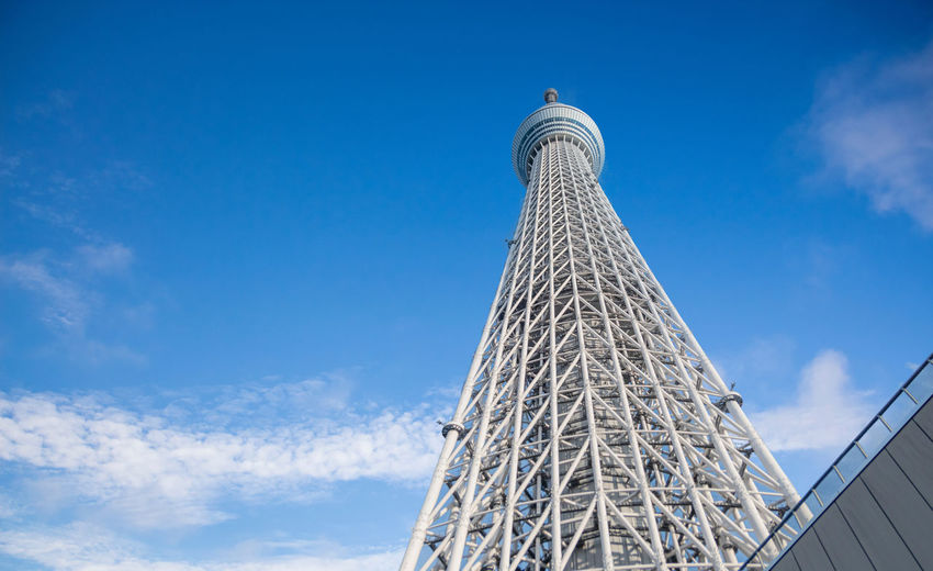 Low angle view of modern building tokyo sky tree against blue sky
