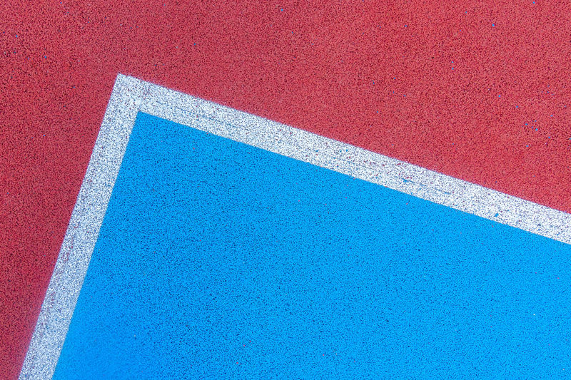 Colorful sports court background. top view to red and blue field rubber ground with white and lines