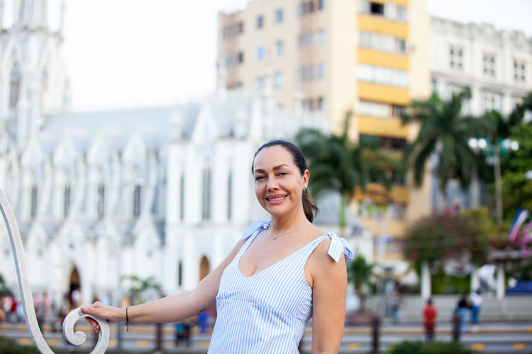Beautiful tourist woman at the ortiz bridge with la ermita church on background in the city of cali