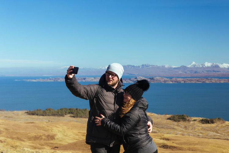Couple taking selfie while standing on land