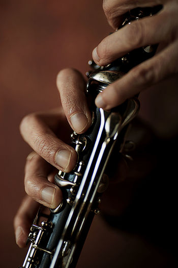 The hands of a musician on the clarinet -  ancient musical wooden instrument popular classical music