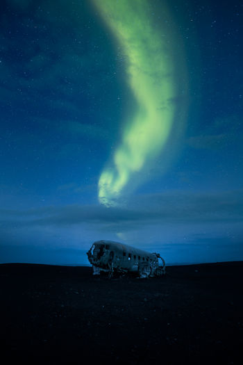 Aurora borealis over abandoned airplane at night
