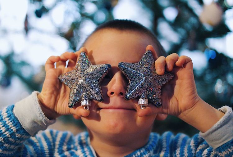 Portrait of kid holding christmas ornaments