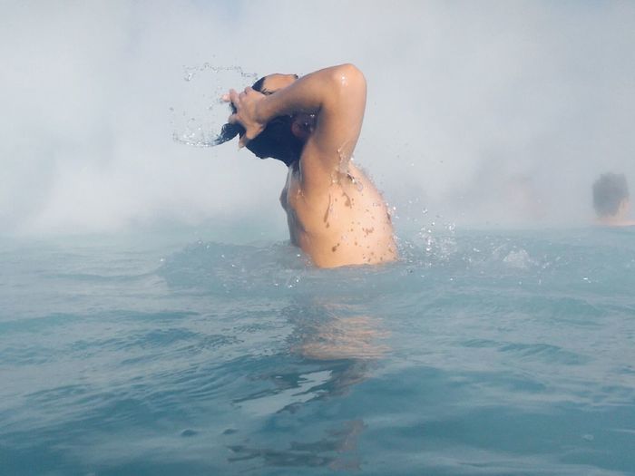 Young man splashing water in sea