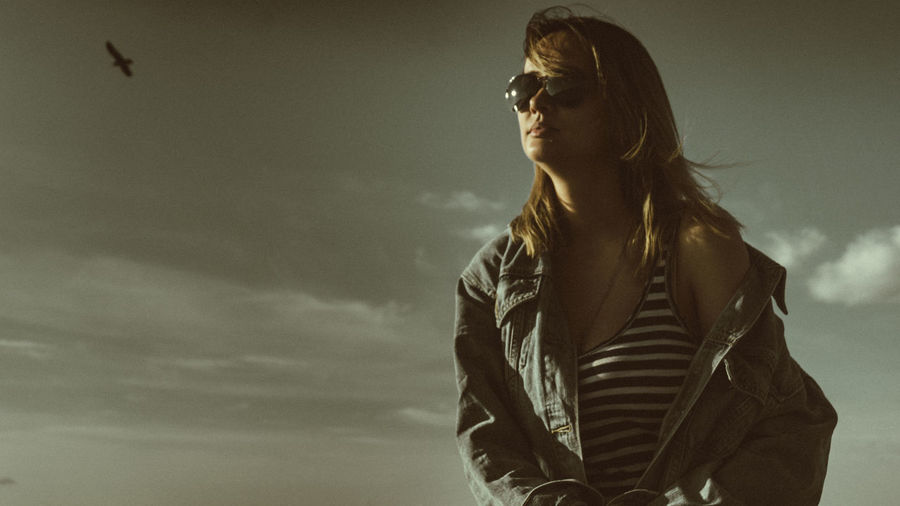 Young woman in sunglasses against sky