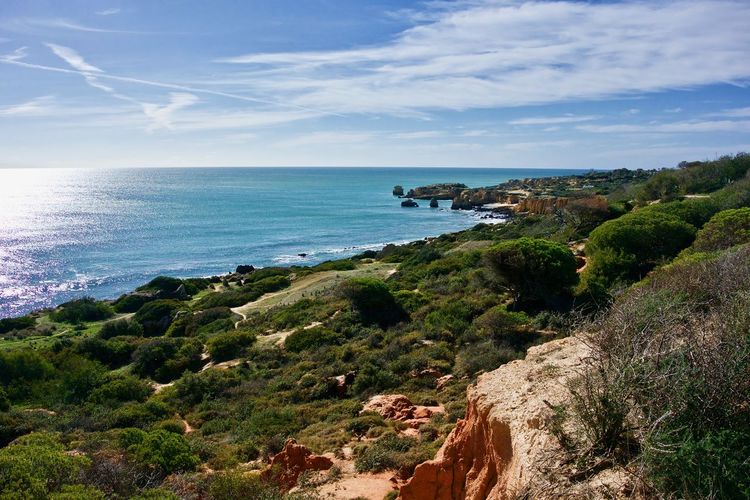 Scenic view of sea and cliff against sky
