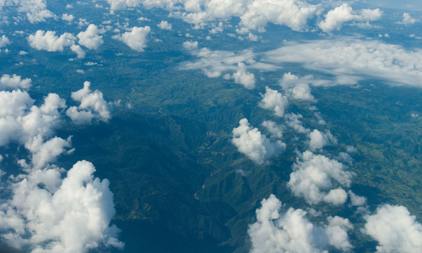 Aerial view of clouds over the green mountain range.