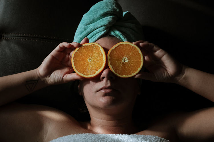 Midsection of woman holding orange slices 