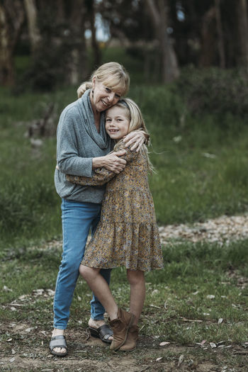 Close up of grandmother and granddaughter smiling in field