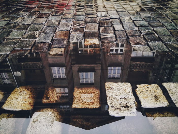 High angle view of building reflecting on puddle