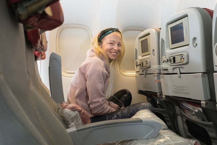 Portrait of smiling woman sitting in airplane