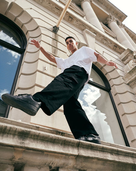 Low angle view of man standing by windows of building