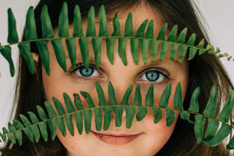 Close-up portrait of girls eyes and fern