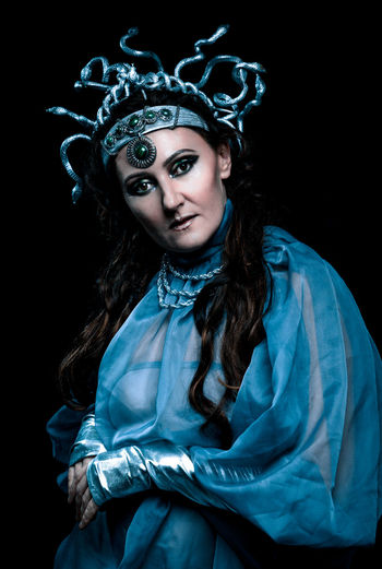 Portrait of woman wearing mask against black background