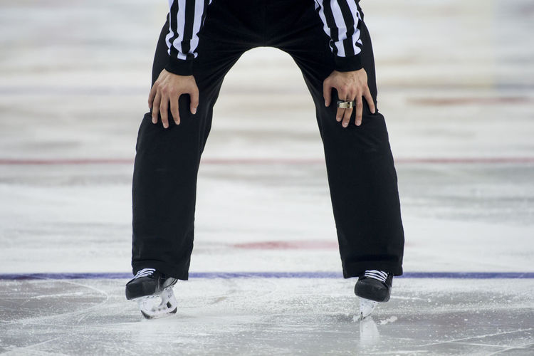 Low section of person ice skating on rink