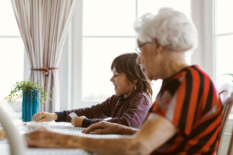 Boy playing cards with great grandmother at home