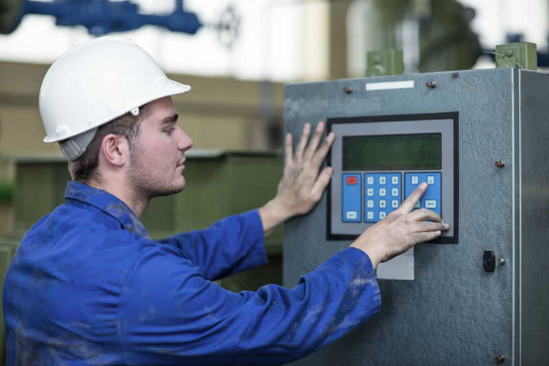 Worker operating machine in factory
