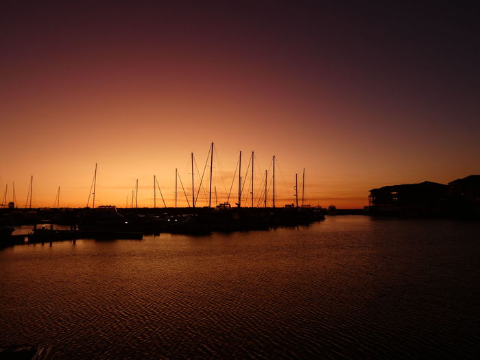 Orange sunset glow with boat silhouettes at mindarie marina.