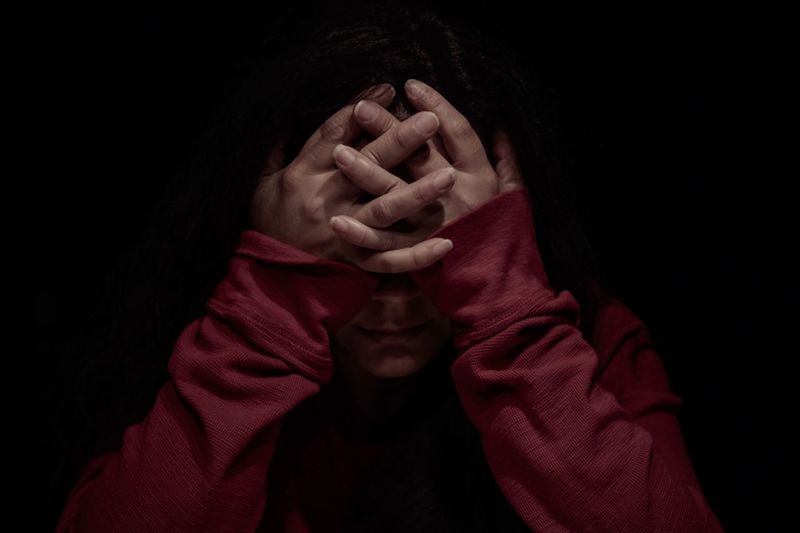 Woman with head in hands in darkroom