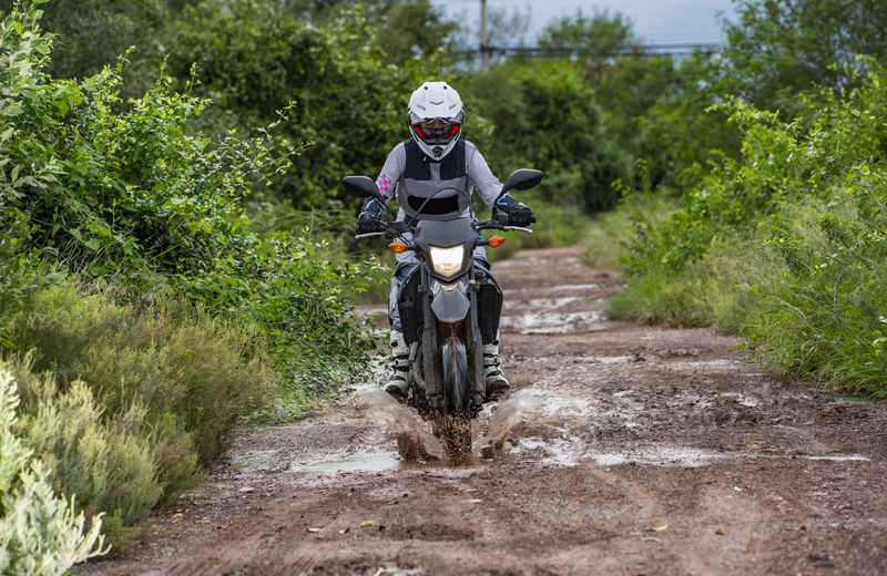 Woman driving her motorbike on dirt road in thailand