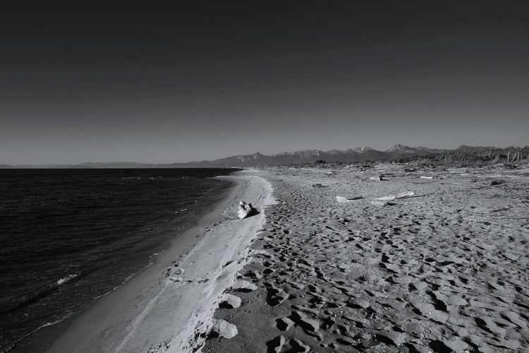 Tire tracks on beach against sky