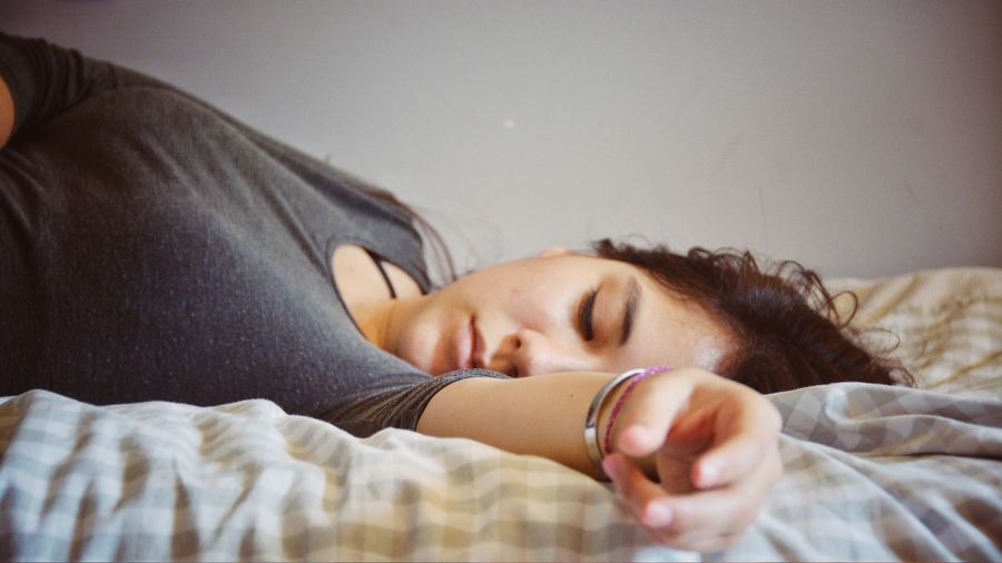 Young woman sleeping on bed at home